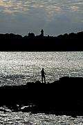 Photo Pêcheur sur la pointe de Kerpenhir, avec le phare de Port-Navalo en arrière plan • Golfe du Morbihan