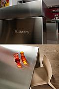 Table en acier brossé gravée Home Inox avec verres colorés sur parquet bois clair à Rennes.