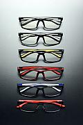 Alignement vertical de six paires de lunettes colorées sur fond gris dégradé avec éclairage studio précis.