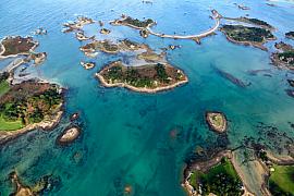 Archipel d’îlots rocheux entourés d’une eau turquoise transparente vue du ciel sur le littoral de Penvénan en Bretagne.