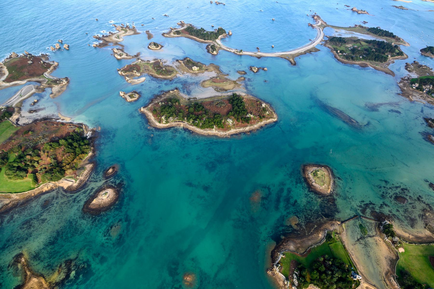 Photographie Christophe Huchet saisit la magie du littoral breton avec cette vue aérienne des îles Banalec et Ozach, révélant les nuances émeraude de la mer.