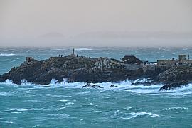 Vagues tumultueuses s’écrasant contre les rochers de la pointe du Décollé à Saint-Lunaire sous un ciel de tempête gris.