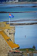 Drapeau de Saint-Malo sur les remparts historiques dominant la plage du Sillon et la mer à marée basse.