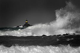 Balise Nerput jaune et noire au milieu de vagues blanches massives sous un ciel sombre d’orage à Saint-Briac.