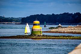 Balise jaune et noire La Truie avec un voilier Guépard aux voiles blanches et jaunes dans le Golfe du Morbihan à Arzon.