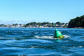 Bouée maritime verte de la Jument oscillant dans les courants vifs du Golfe du Morbihan face aux côtes de Larmor-Baden.