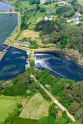 Vue aérienne du moulin du Roc’h Du avec l’eau s’écoulant dans le bassin entouré de végétation et de maisons à Locmariaquer.