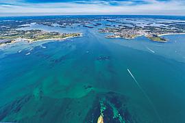 Vue du ciel des eaux turquoise et des côtes bretonnes entre Port-Navalo et Locmariaquer par un temps clair et ensoleillé.