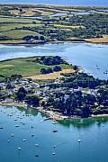 Vue aérienne du petit port du Logeo avec de nombreux bateaux au mouillage sur une eau turquoise bordée de maisons et de verdure.