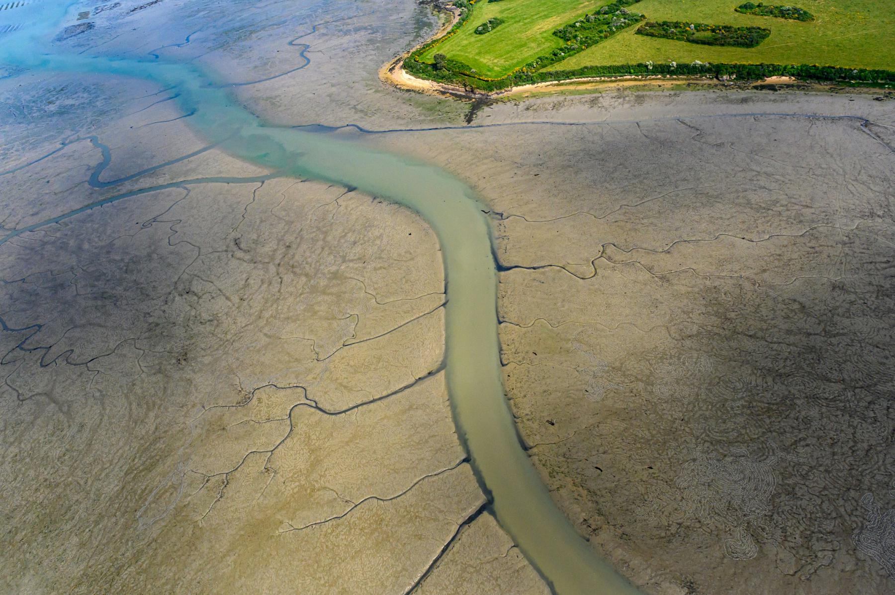 Vue aérienne de vasières et chenaux sinueux à la pointe du Bernon à Sarzeau par marée basse dans le Golfe du Morbihan.