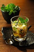 Verrine transparente garnie de crabe et soja décorée de menthe fraîche sur un plat noir texturé sous une lumière chaude.