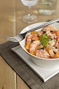 Bol de salade de gambas, surimi et quartiers d’oranges avec une fourchette posée sur le rebord, lumière naturelle.