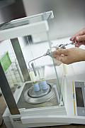 Gros plan sur l’analyse d’échantillons de lait avec une balance de précision et une pipette dans un laboratoire breton.