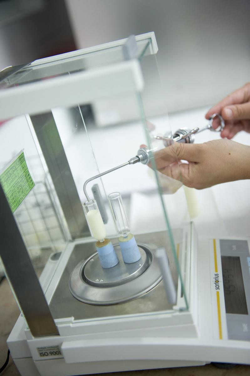 Gros plan sur l’analyse d’échantillons de lait avec une balance de précision et une pipette dans un laboratoire breton.