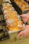 Mains manipulant un moule de brioche tressée au sucre dans une unité de production agroalimentaire en Pays de la Loire