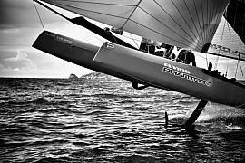 Photographie Photographe nautique et voile, je capte l'immersion au cœur d'une régate avec un Flying Phantom volant au-dessus des vagues. Une œuvre en noir et blanc illustrant la beauté des bateaux volants au dessus de l'eau