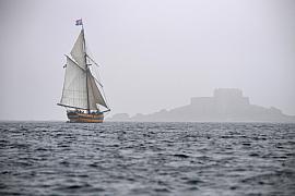 Photographie Photographe nautique et voile, je capte Le Renard émergeant de la brume malouine. Une atmosphère mystique illustrant l'héritage maritime des vieux gréements bretons.
