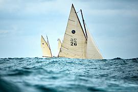 Photographie Photographe de la Bretagne, des voiliers et paysages marins, je capte le cœur d'une régate de vieux gréements en Bretagne. Cette prise de vue au ras de l'eau souligne la puissance des voiles classiques.