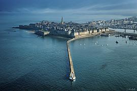Vue aérienne du môle des Noires avec son phare blanc et rouge face aux remparts de Saint-Malo en Ille-et-Vilaine.