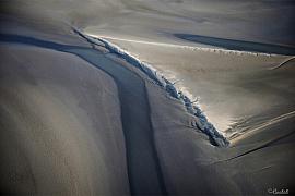 Vue rapprochée de crêtes de sable aux formes géométriques et ombres portées dans la baie du Mont Saint-Michel.