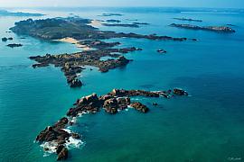 Archipel des Ebihens vu du ciel, eaux turquoise cristallines entourant îlots rocheux et bancs de sable en Bretagne Nord.
