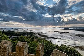Estran de l’Arcouest à Paimpol à marée basse sous un ciel chargé. Reflets sur l’eau et rochers côtiers bretons.