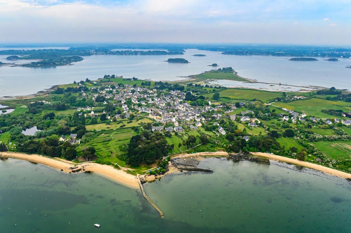 Vue du ciel du village de l’île d’Arz avec la cale de Pen Raz bordant les eaux turquoise du Golfe du Morbihan.