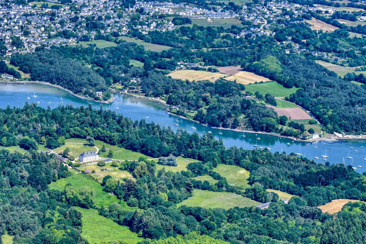 Vue aérienne de la rivière d’Auray et du château de Kérantré entourés de forêts denses et de champs en Bretagne.