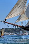 Marin sur le beaupré d’un voilier traditionnel aux voiles blanches déployées dans le Golfe du Morbihan sous le soleil.