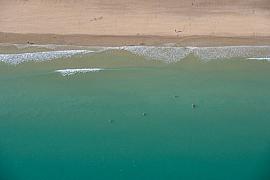 Vue verticale plage sable blond vagues écume blanche eau turquoise baigneurs Binic Côtes d’Armor