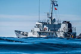 Navire de la Marine nationale Française, sur une mer bleue agitée lors du départ d’une régate sous un ciel clair.