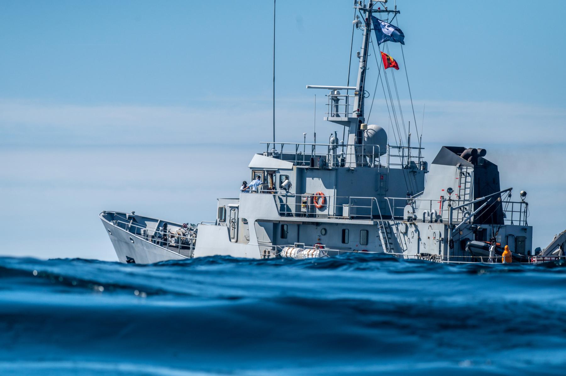 Navire de la Marine nationale Française, sur une mer bleue agitée lors du départ d’une régate sous un ciel clair.