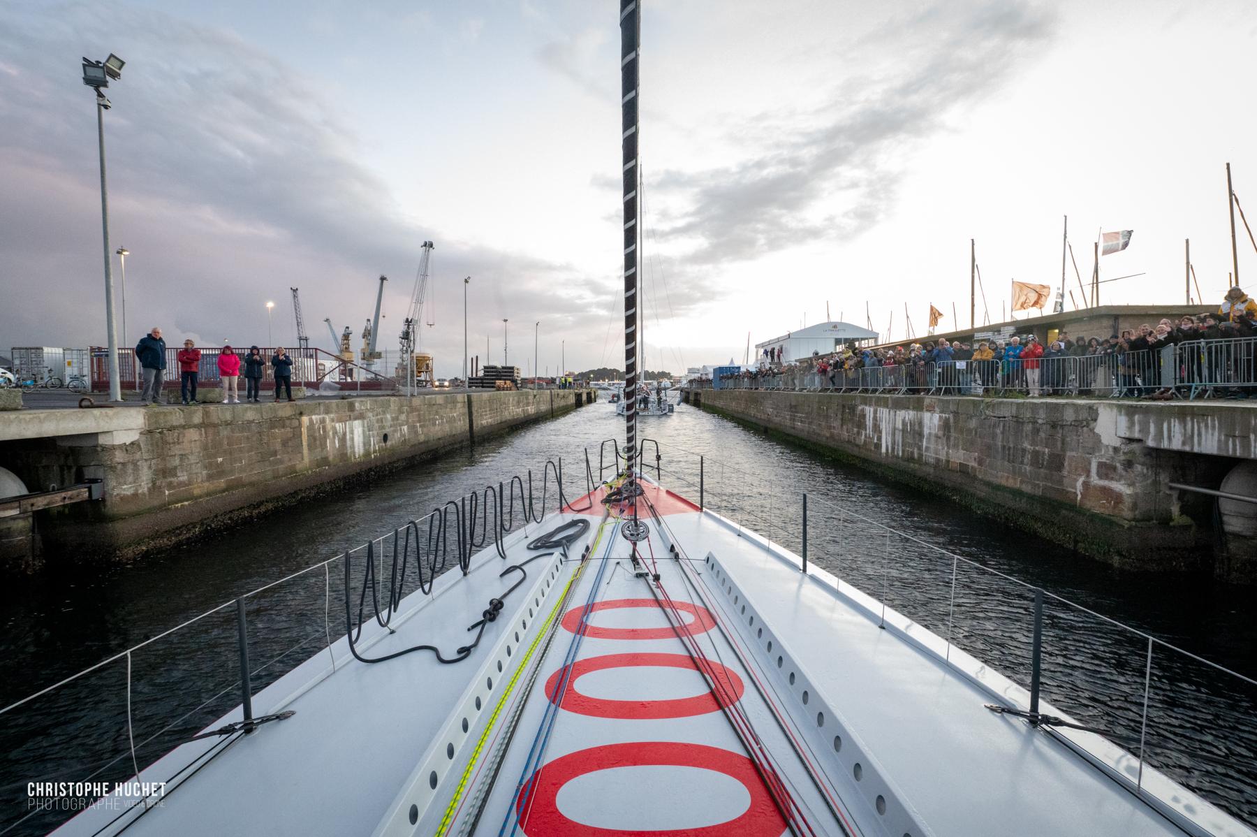 Photographie Photographe nautique et voile, je capte l'immersion à la Route du Rhum 2022. Tanguy Le Turquais et l'Imoca Lazare quittent les écluses de Saint-Malo devant un public passionné.