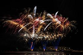 Explosions pyrotechniques dorées et rouges au-dessus de l’eau aux Sables d’Olonne en pleine nuit