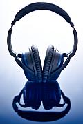 Casque audio Bose bleu reposant sur un support brillant avec reflet symétrique, éclairage studio contrasté et net.