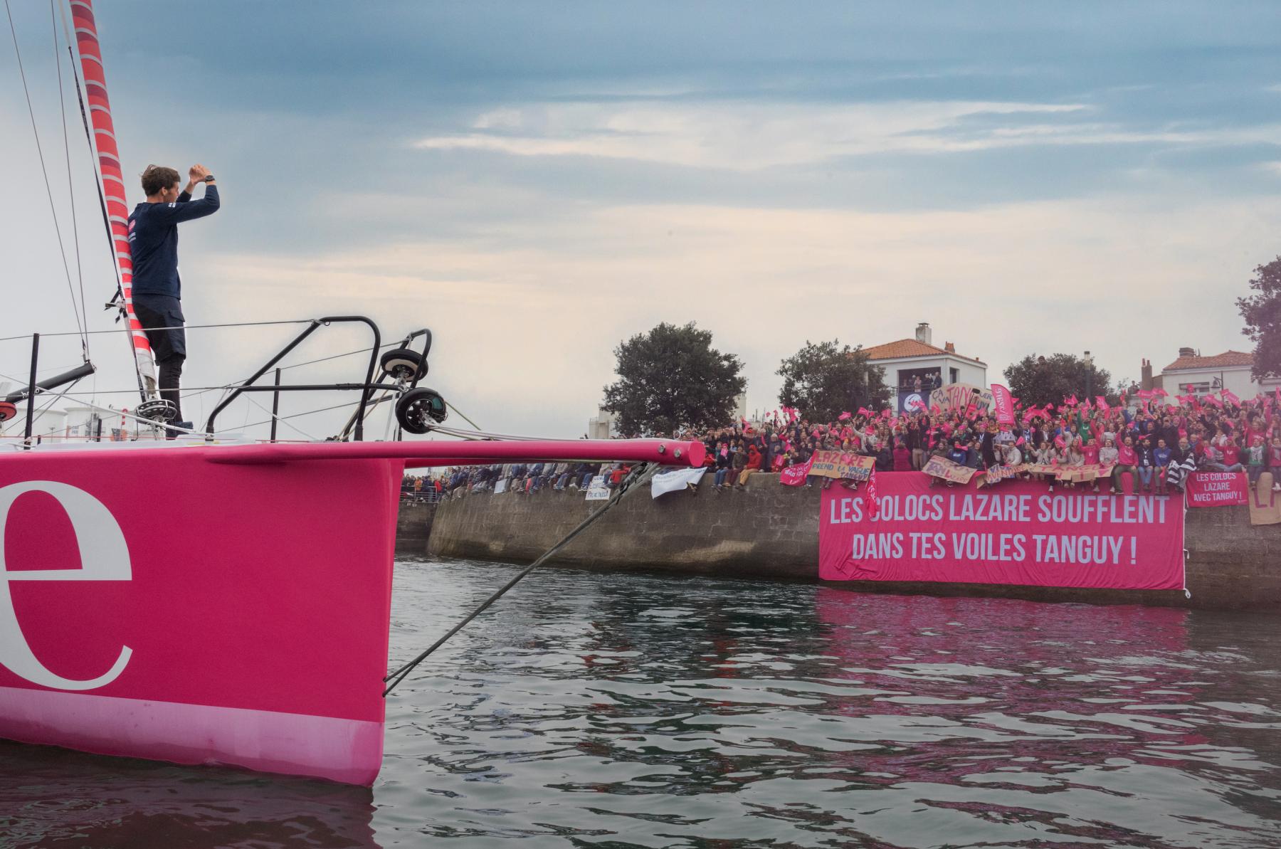 Navigateur Tanguy Le Turquais sur l’IMOCA rose Lazare saluant la foule sur le chenal des Sables-d’Olonne