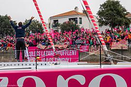 Tanguy Le Turquais bras levés sur l’IMOCA Lazare devant une foule en rose aux Sables-d’Olonne.