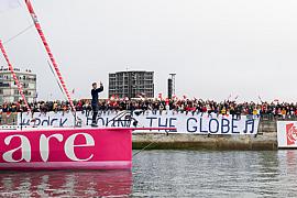 Tanguy Le Turquais debout sur l’Imoca Lazare rose devant une foule aux Sables d’Olonne lors du Vendée Globe