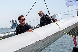 Deux skippers manoeuvrant sur un trimaran Ocean Fifty blanc au large de Saint-Malo.