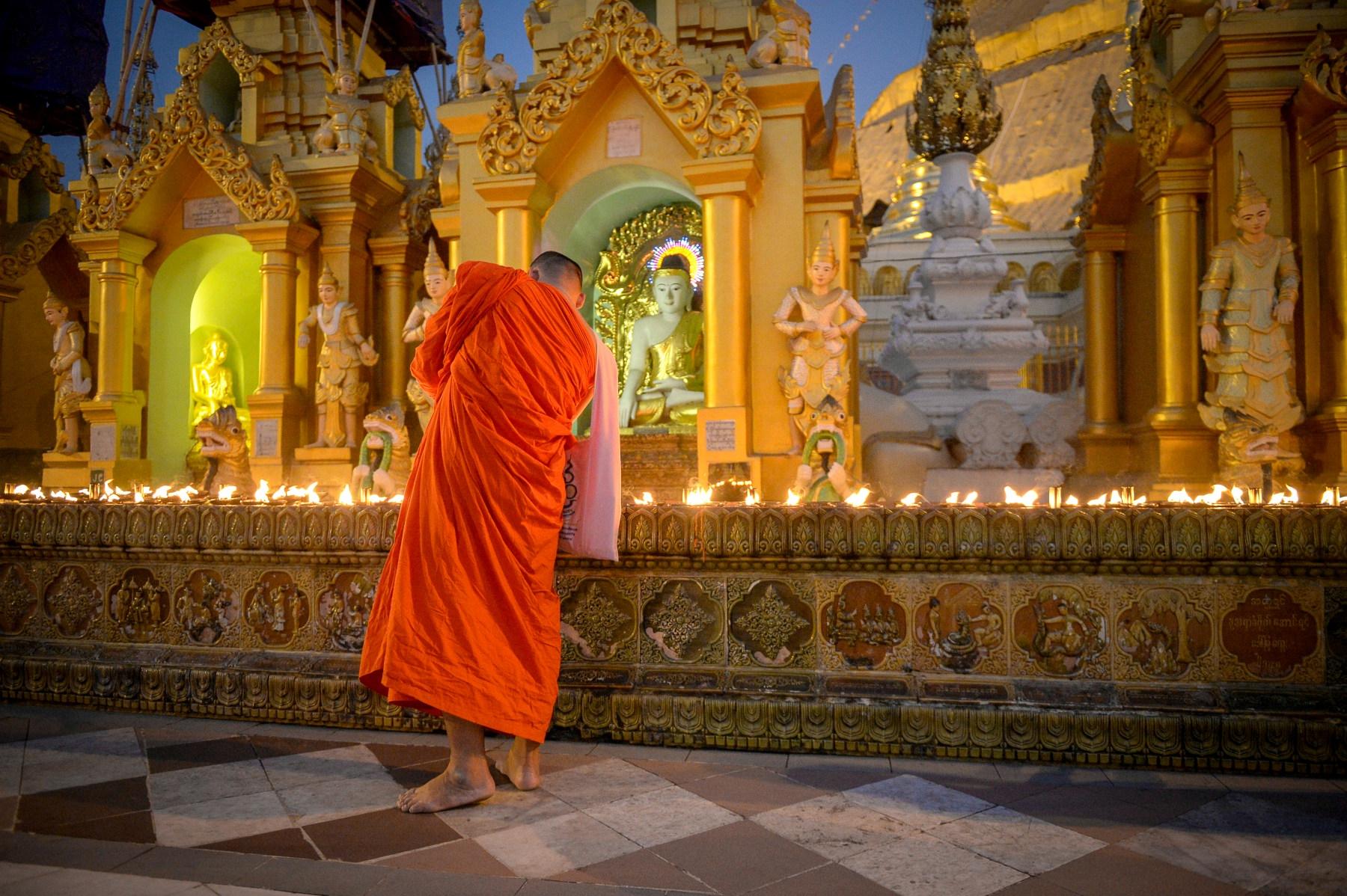 Photo Moine bouddhiste en robe safran devant les sanctuaires de la pagode Shwedagon à Rangoon