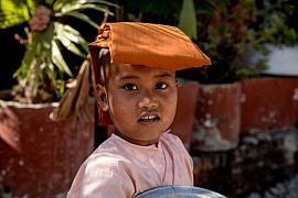 Photo Jeune novice bouddhiste faisant l’aumône dans une rue de Mandalay