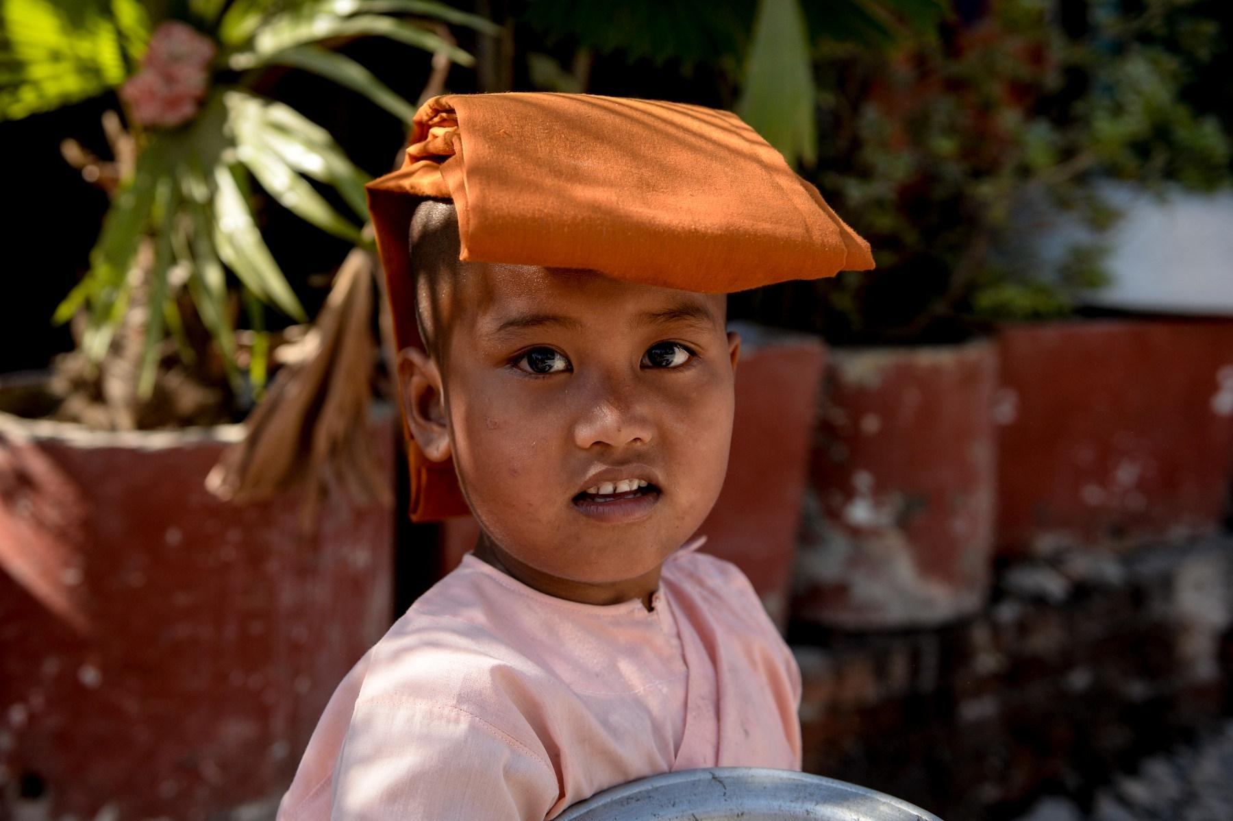 Photo Jeune novice bouddhiste faisant l’aumône dans une rue de Mandalay