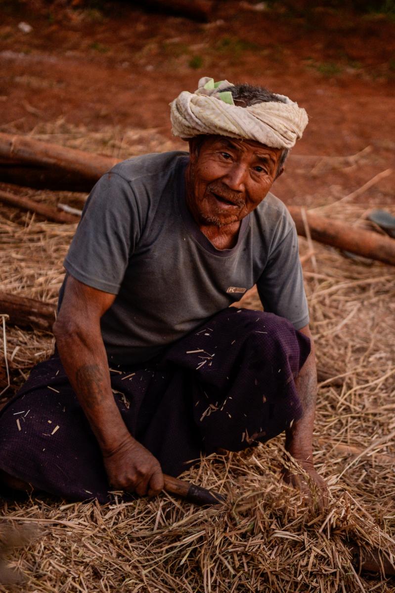 Photo Homme âgé assis, travaillant la paille près du lac Inle en Birmanie