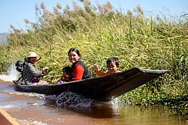 Photo Famille naviguant en pirogue à moteur sur les eaux du lac Inle, témoignant du transport typique en Birmanie et dans l’asie du sud-est