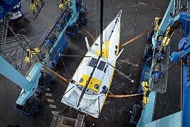 Imoca Café Joyeux suspendu à un travel lift  dans le port de Lorient, vue aérienne réalisée au drone
