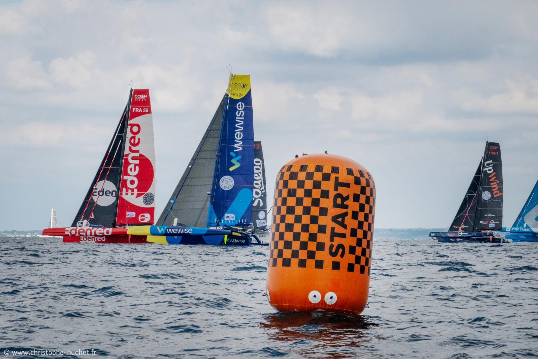 Trimarans Ocean Fifty frôlant une bouée orange à damier lors du départ des 24h Ultims