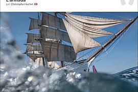 Trois-mâts Le Français naviguant à Lorient avec éclaboussures d’eau au premier plan sous un ciel bleu dégagé.