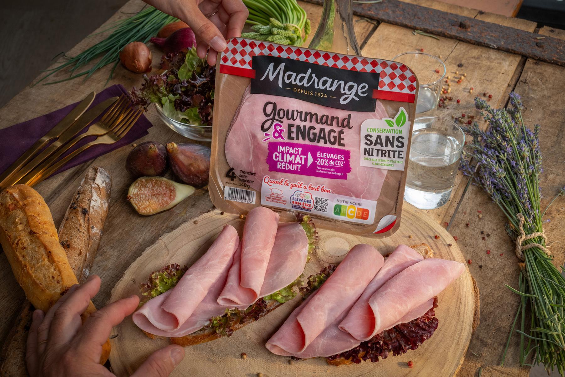 Tranches de jambon sur tartines avec figues et herbes sur table en bois rustique sous lumière naturelle.