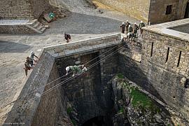 Stagiaire traversant un ravin sur les cables du Fort de Penthièvre, groupe en treillis observant depuis les remparts 
